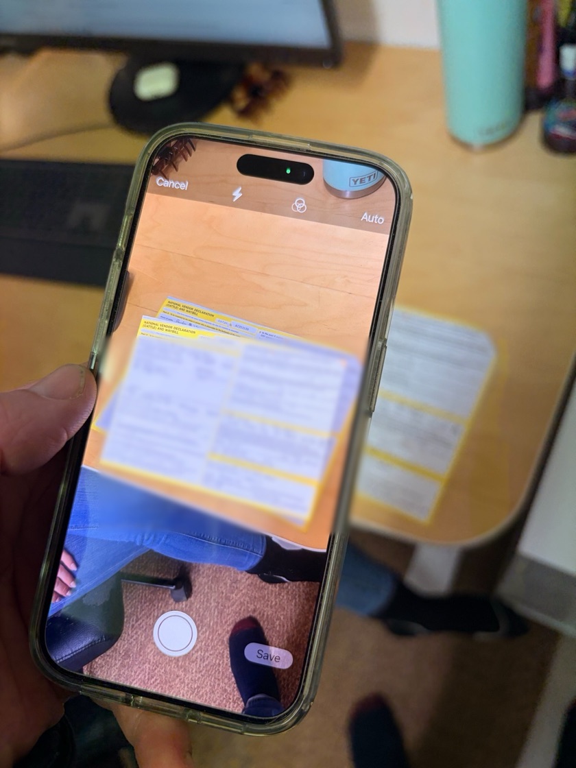 A phone photographing a paper NVD on a desk